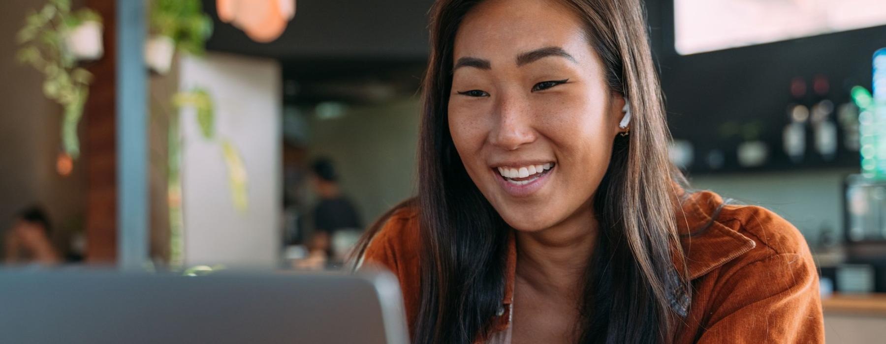 a woman smiling while working on laptop